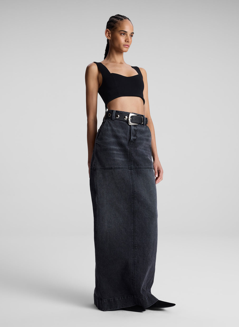 woman wearing black compact knit bra and black denim maxi skirt