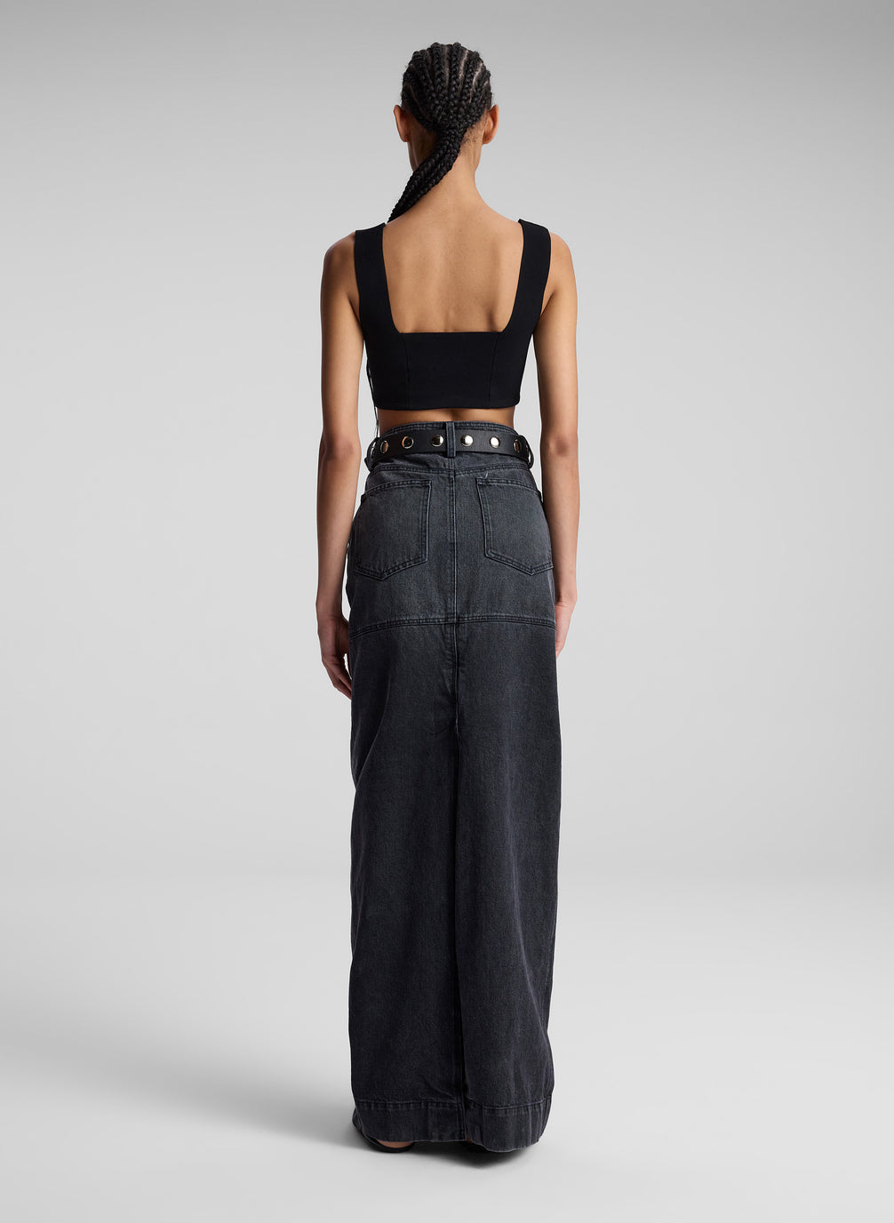 woman wearing black compact knit bra and black denim maxi skirt