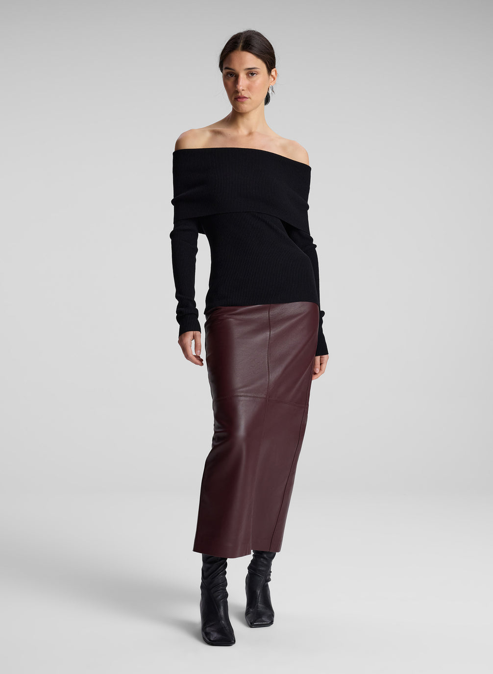 woman wearing black off shoulder top and maroon leather skirt