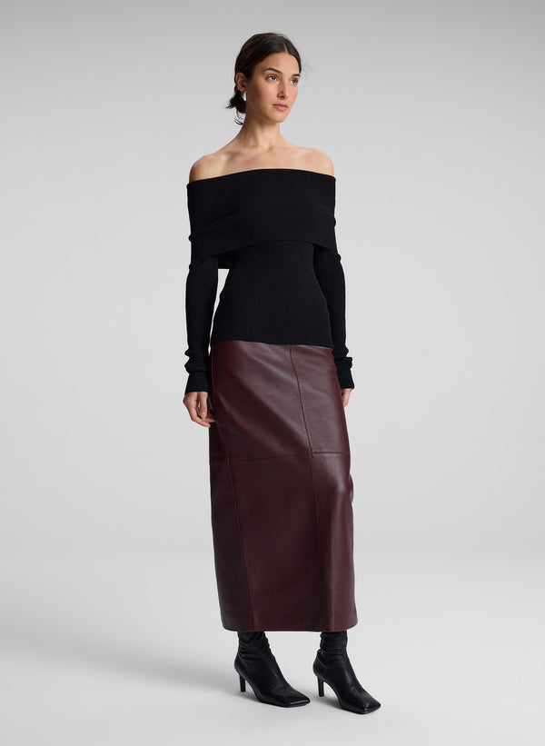 woman wearing black off shoulder top and maroon leather skirt