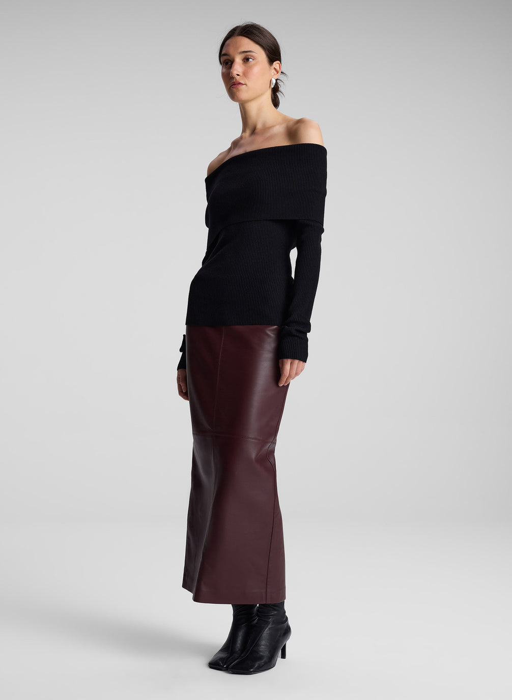 woman wearing black off shoulder top and maroon leather skirt