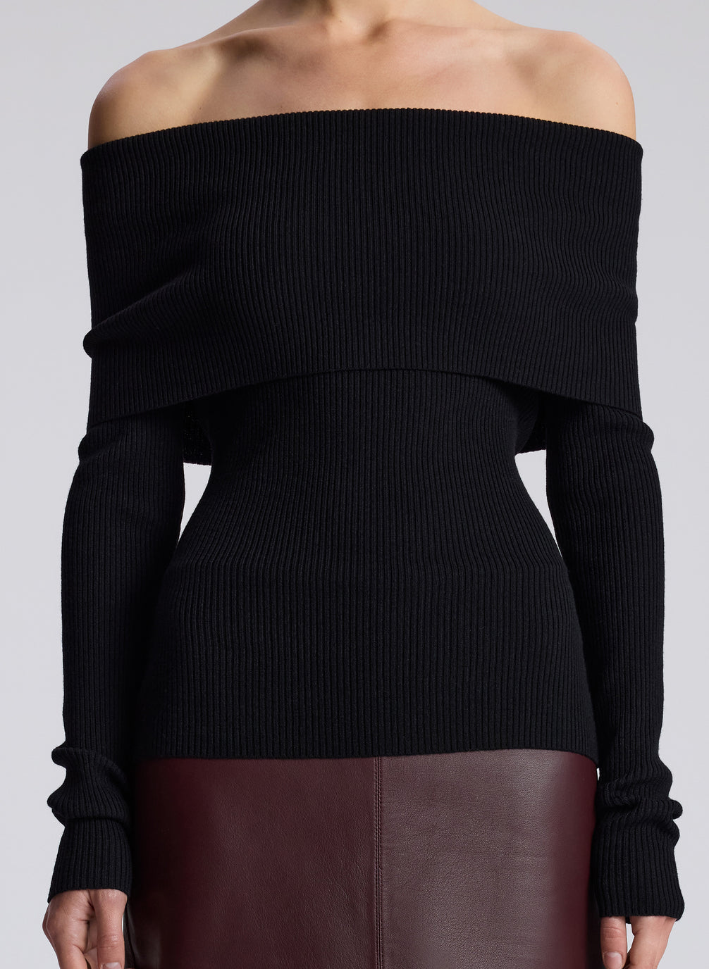 woman wearing black off shoulder top and maroon leather skirt