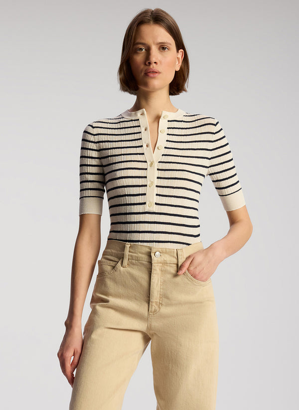front view of woman wearing navy blue and white striped shirt and tan pants