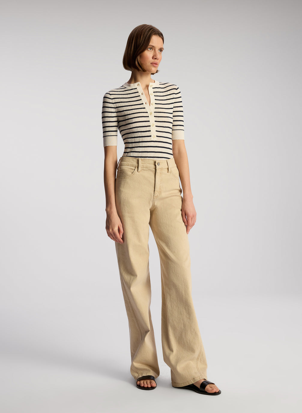 view of woman wearing navy blue and white striped shirt and tan pants
