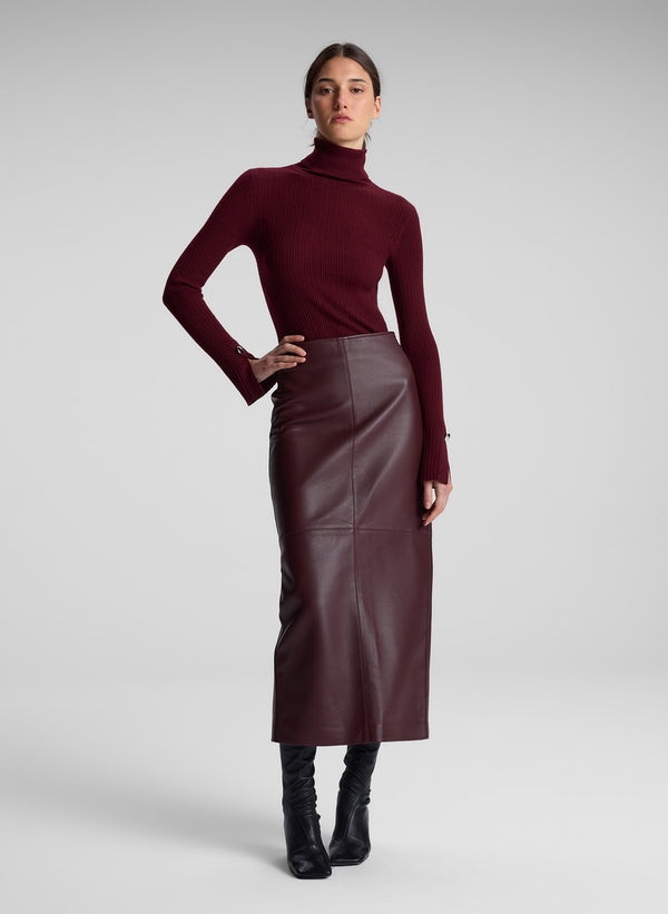 woman wearing burgundy turtleneck and maroon leather maxi skirt