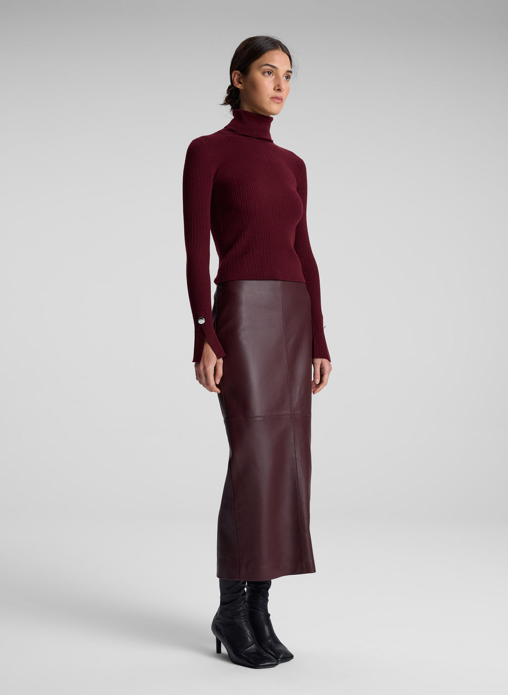 woman wearing burgundy turtleneck and maroon leather maxi skirt