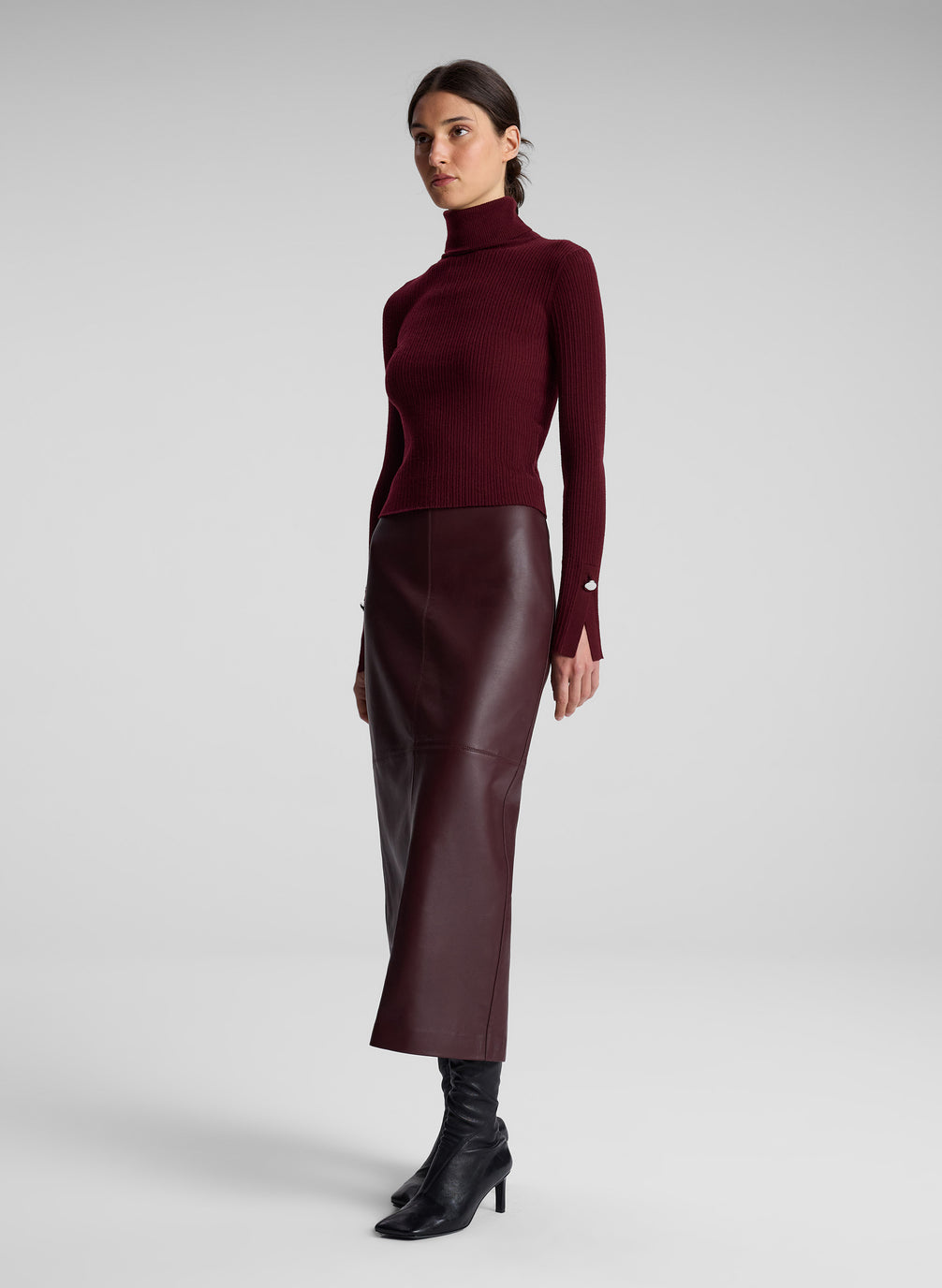 woman wearing burgundy turtleneck and maroon leather maxi skirt