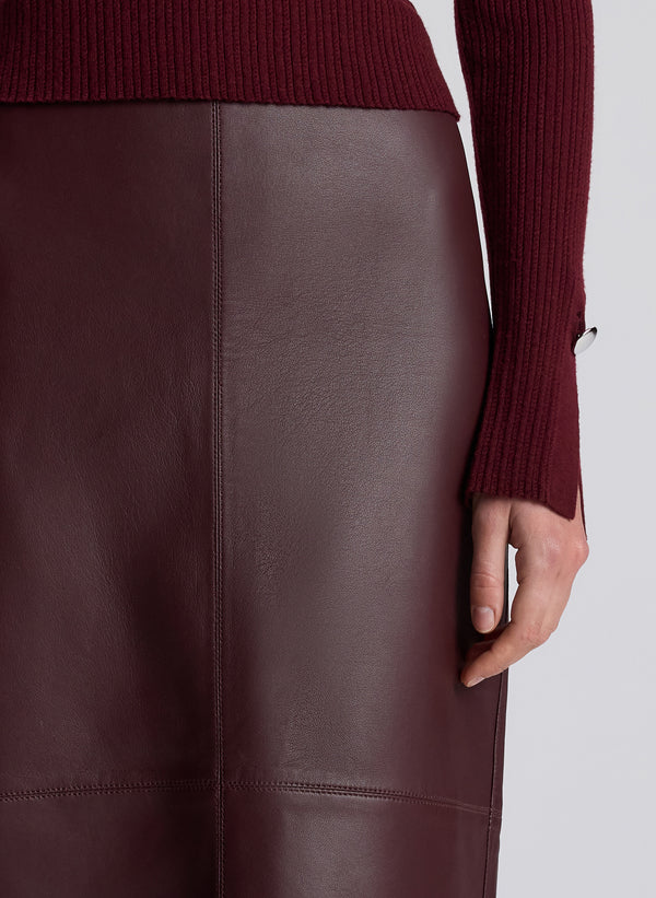 woman wearing burgundy turtleneck and maroon leather maxi skirt