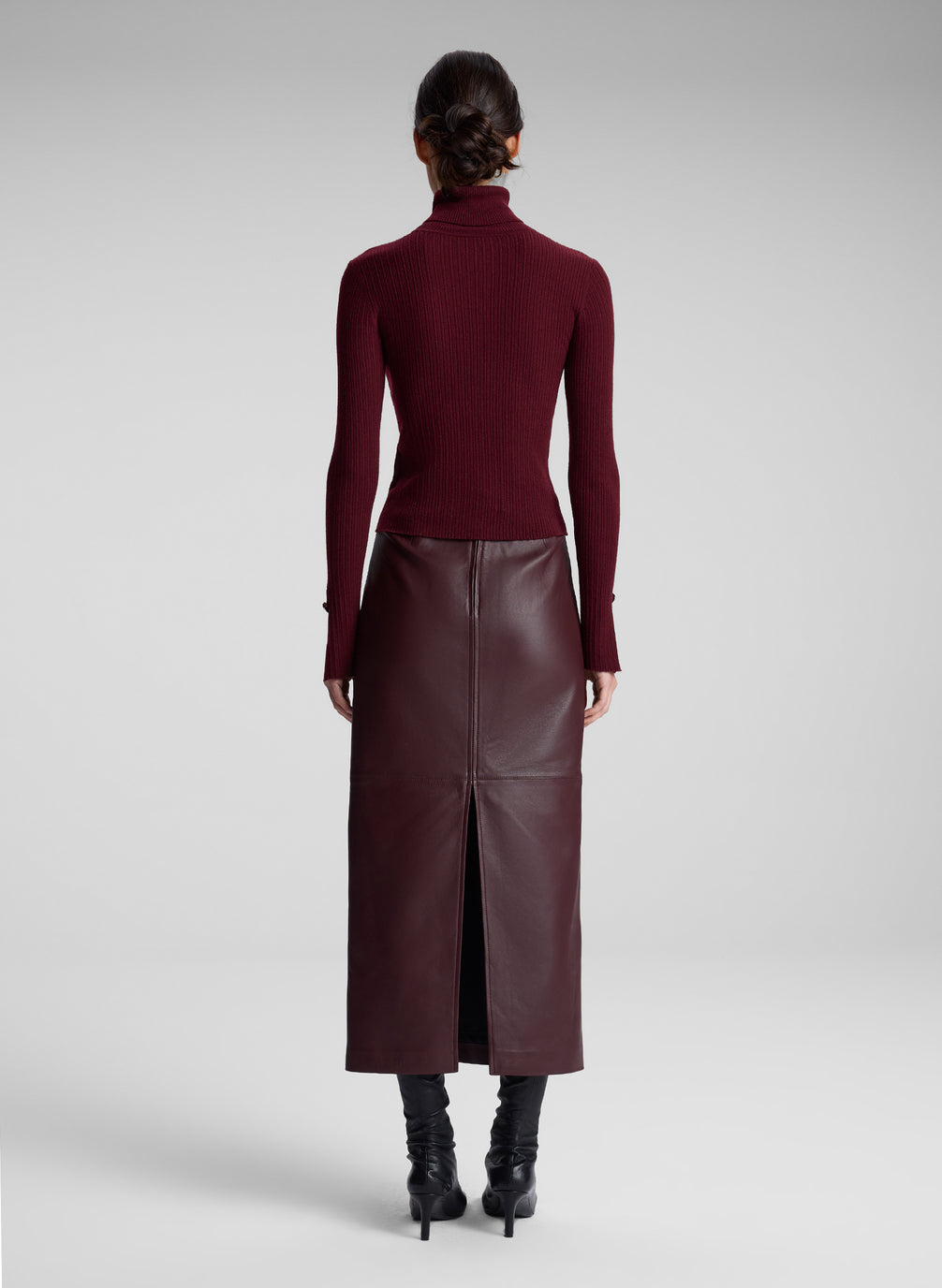 woman wearing burgundy turtleneck and maroon leather maxi skirt