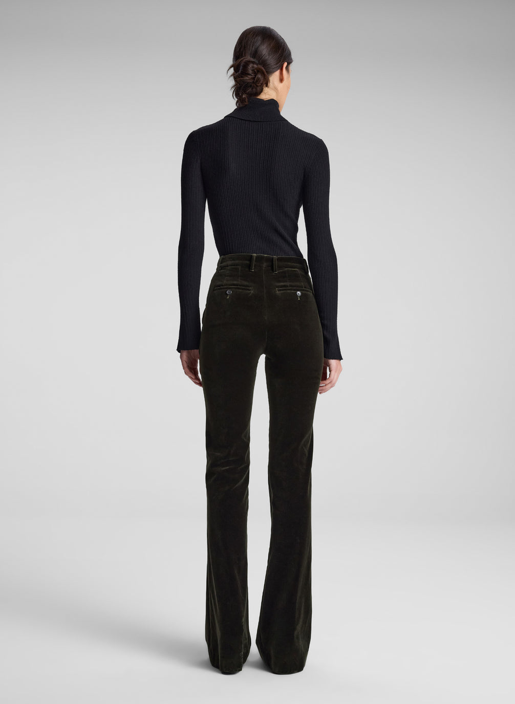 woman wearing black turtleneck and olive green velvet pants