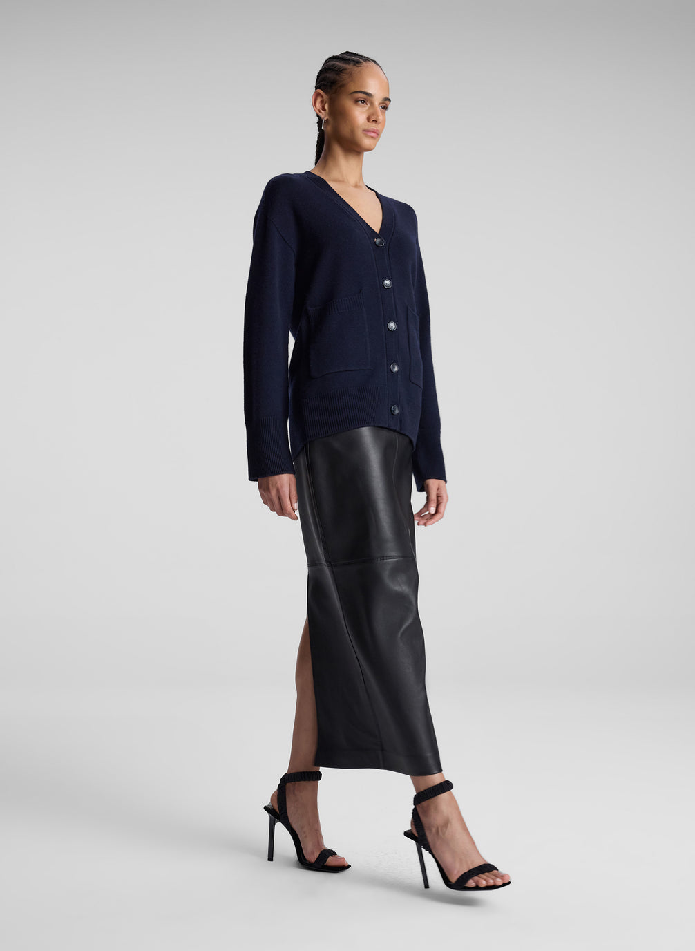 woman wearing navy blue cardigan and back leather midi skirt