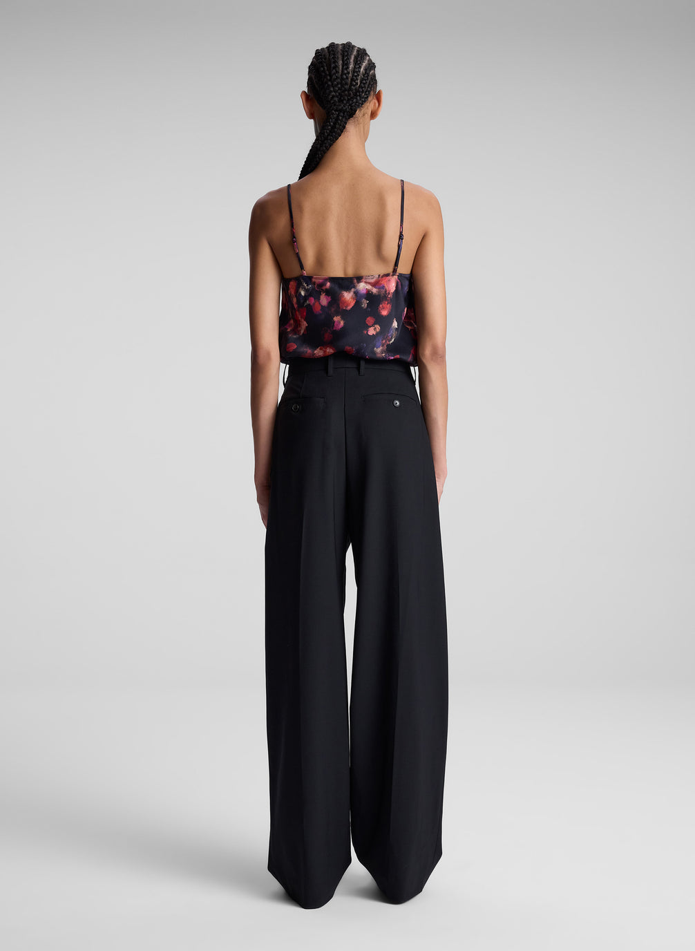 woman wearing printed satin camisole and black pants