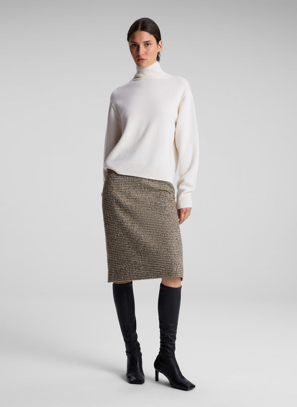 woman wearing white turtleneck and brown midi skirt