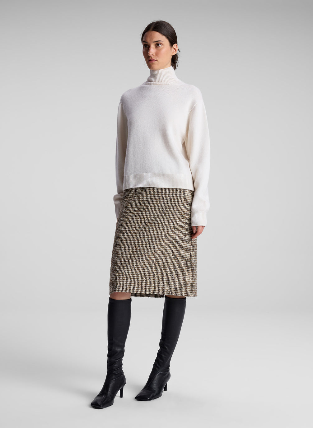 woman wearing white turtleneck and brown midi skirt