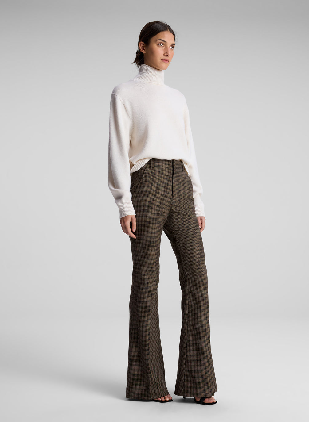 woman wearing white sweater and brown pants