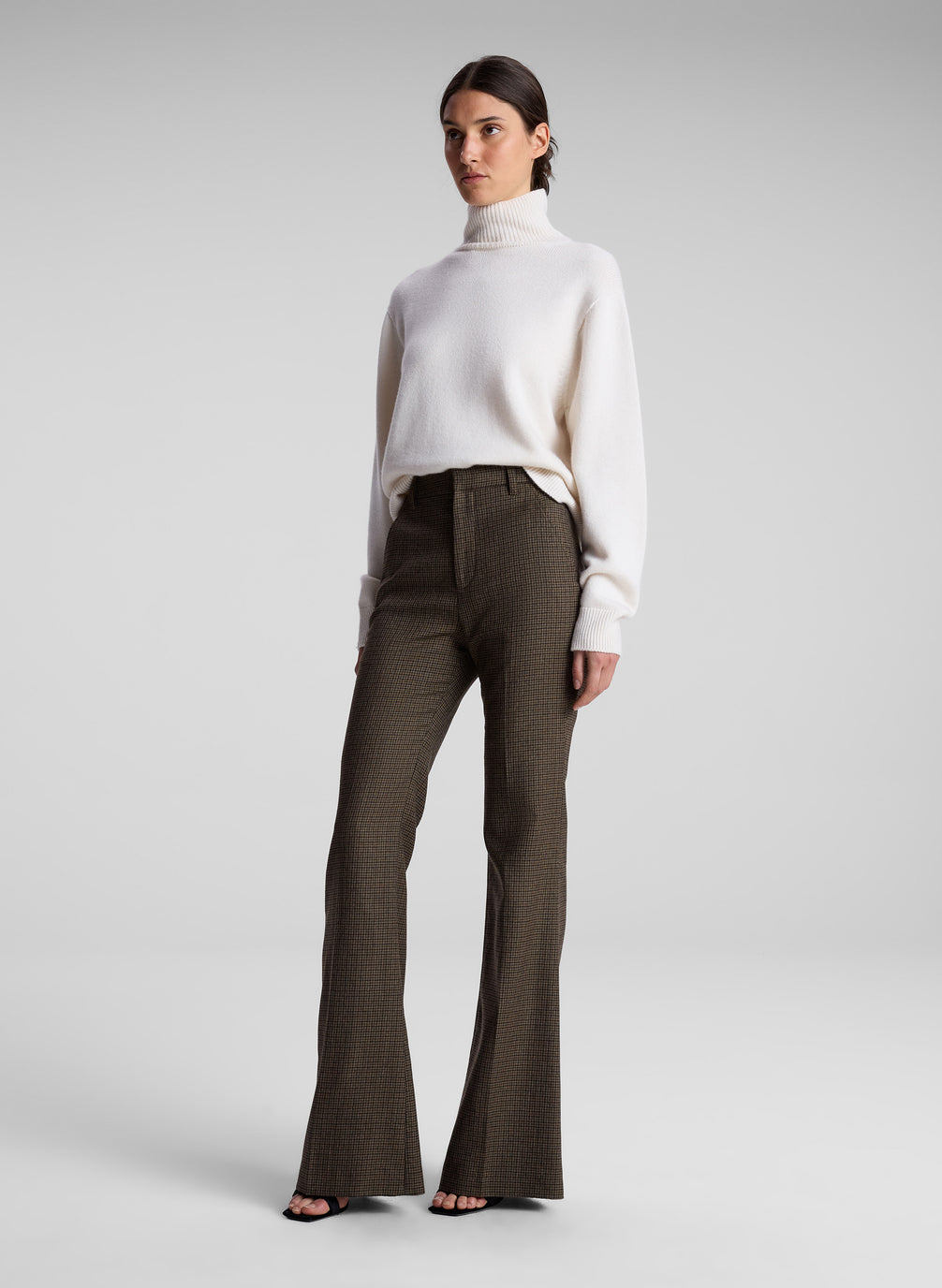 woman wearing white sweater and brown pants