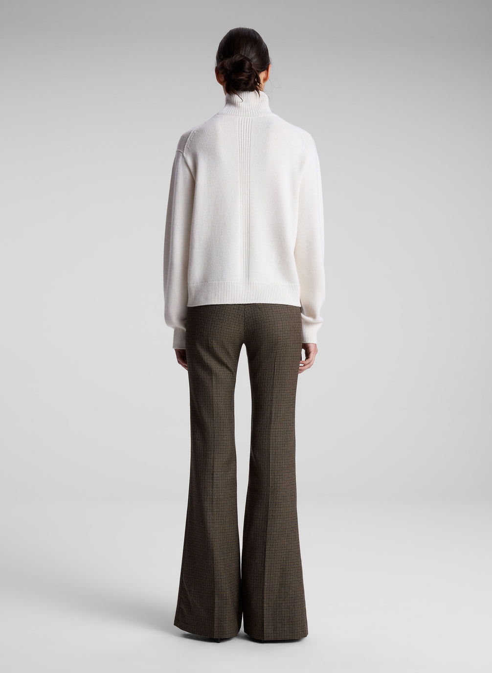 woman wearing white sweater and brown pants