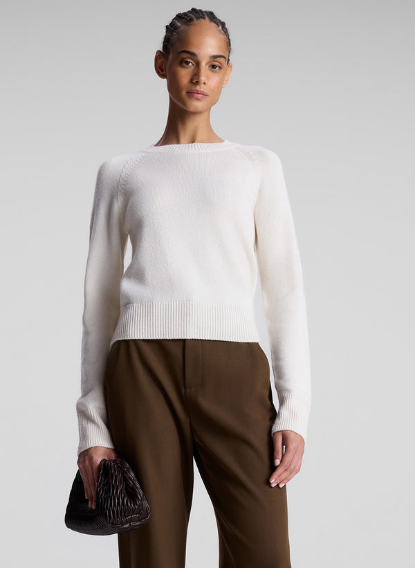 woman wearing white sweater and brown pants