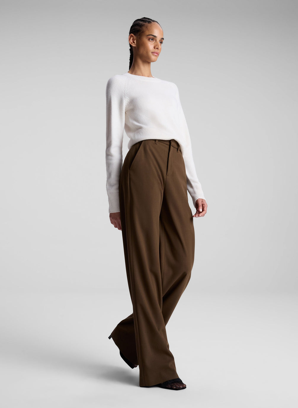 woman wearing white sweater and brown pants