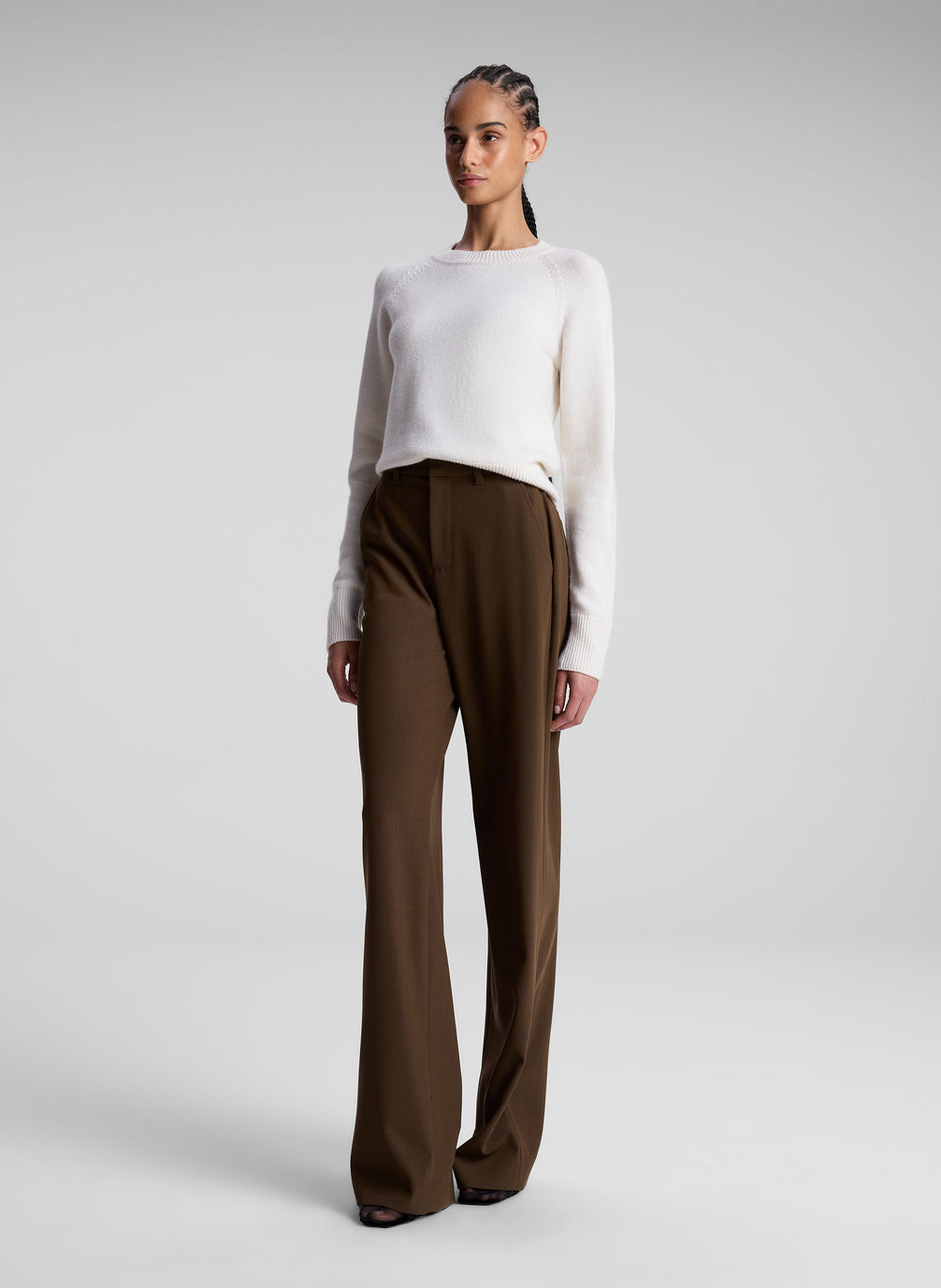 woman wearing white sweater and brown pants