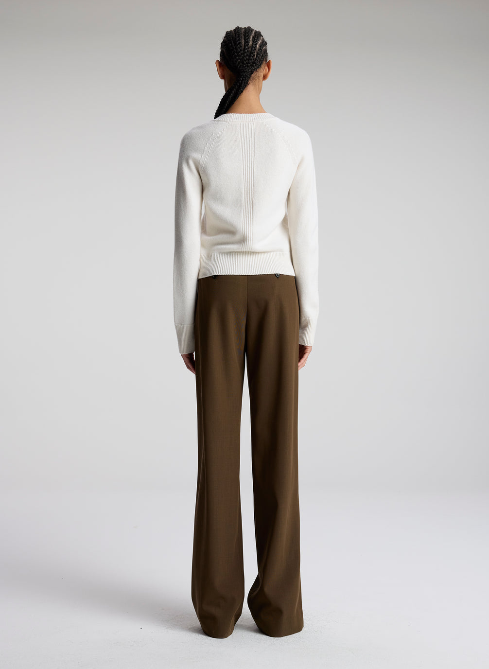 woman wearing white sweater and brown pants