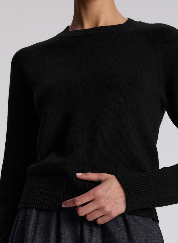 detail shot of woman wearing solid black long sleeve sweater