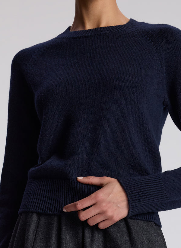 woman wearing navy blue sweater and charcoal grey pants