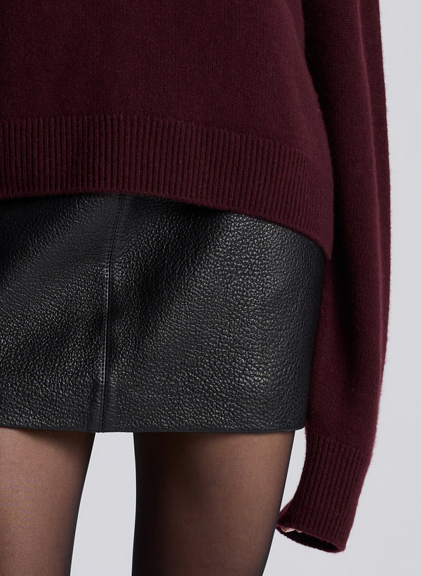 woman wearing burgundy sweater and black leather mini skirt