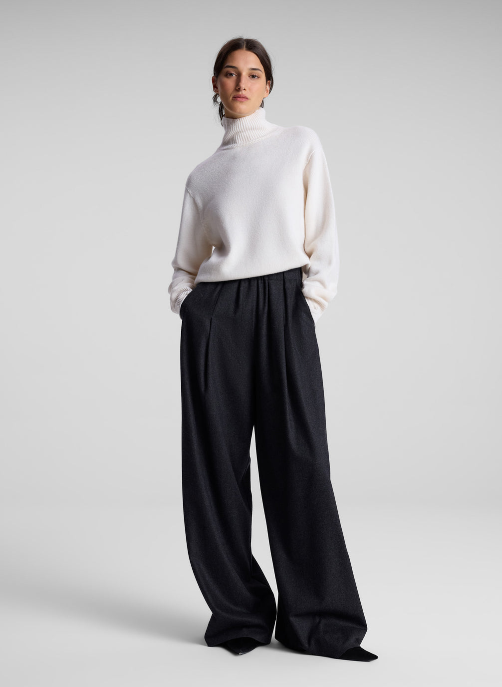 woman wearing white turtleneck sweater and charcoal grey wide leg pants