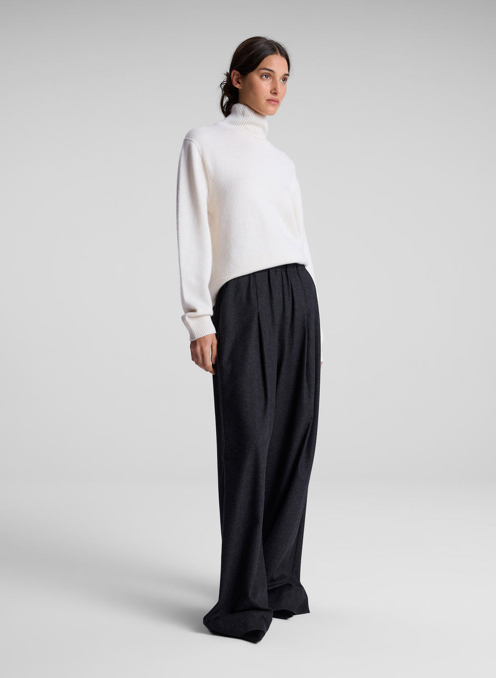 woman wearing white turtleneck sweater and charcoal grey wide leg pants