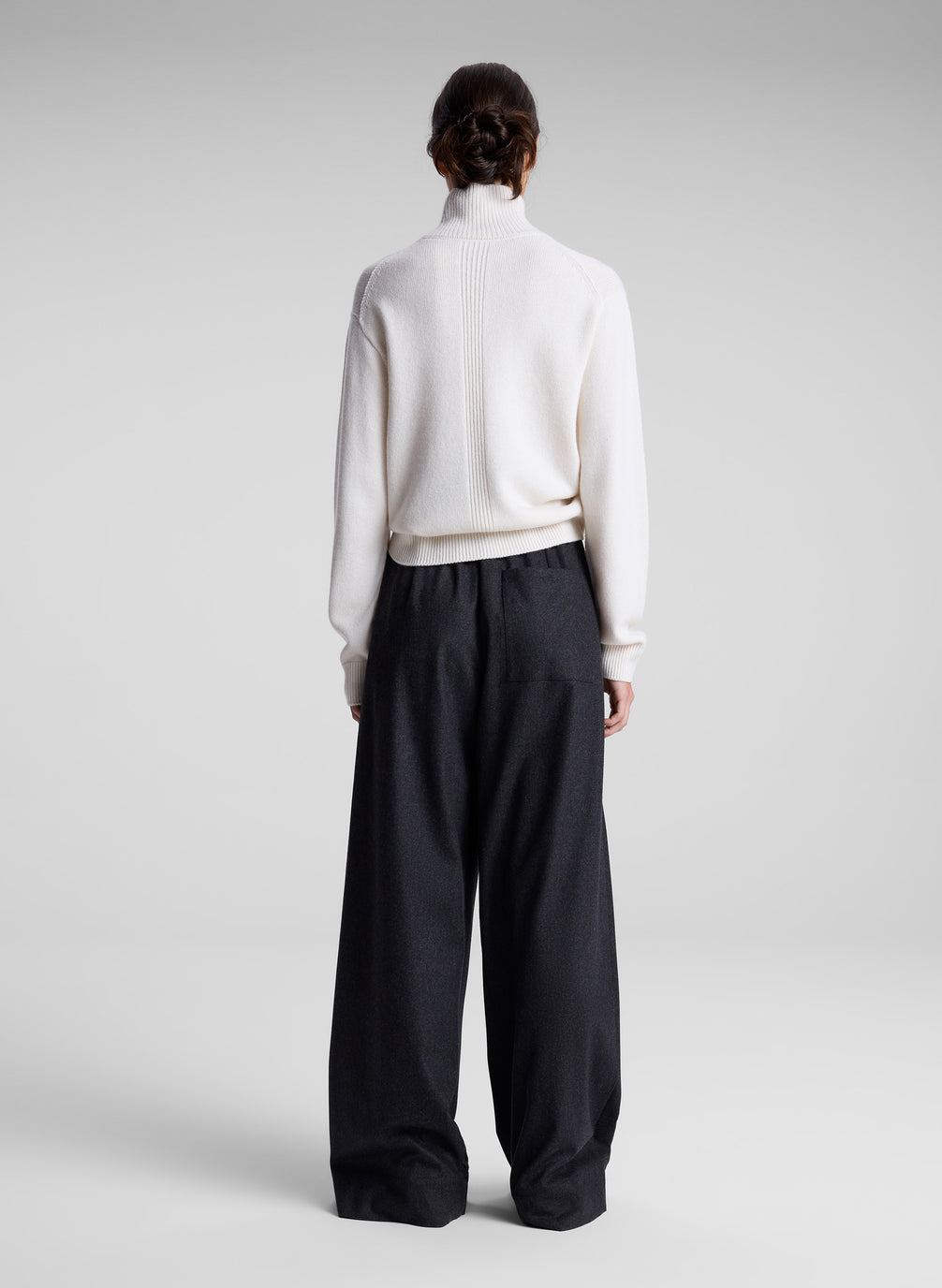 woman wearing white turtleneck sweater and charcoal grey wide leg pants