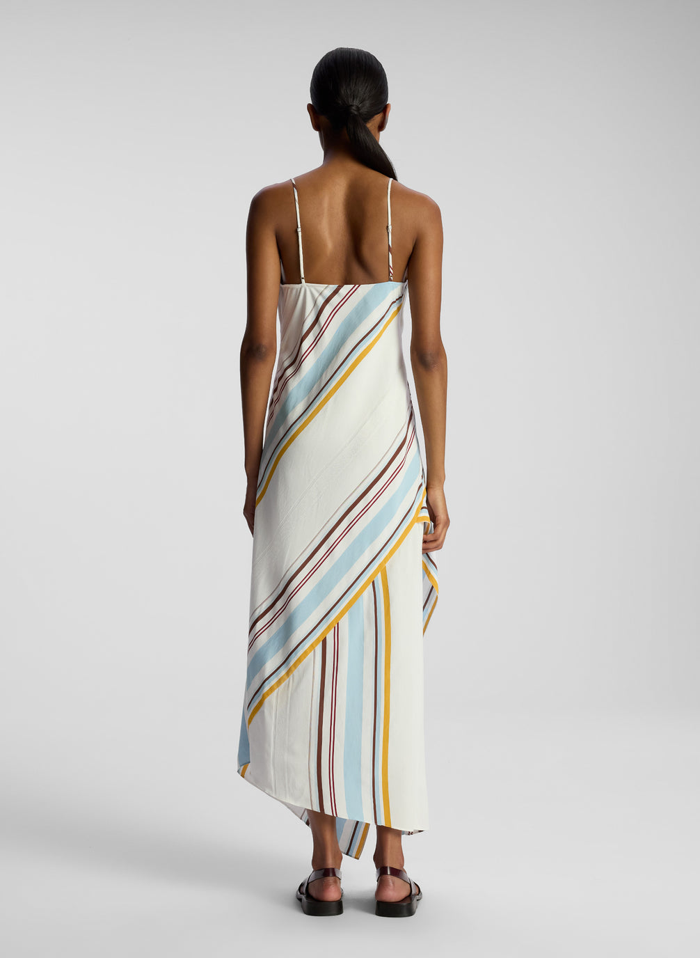 back view of woman wearing multi color striped midi dress