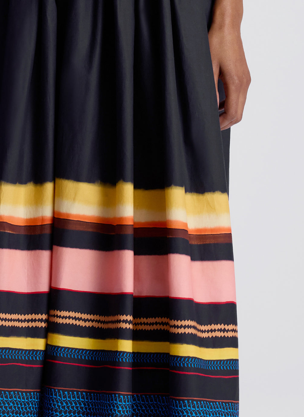 detail view of woman wearing navy blue striped strapless midi dress