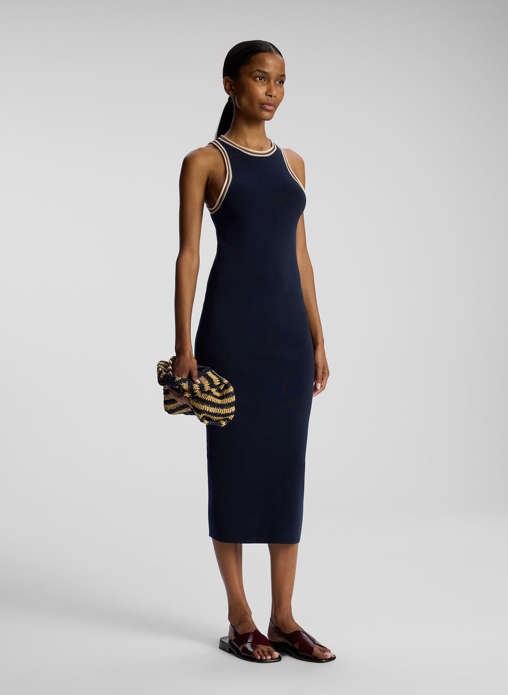 side view of woman wearing navy blue sleeveless knit midi dress