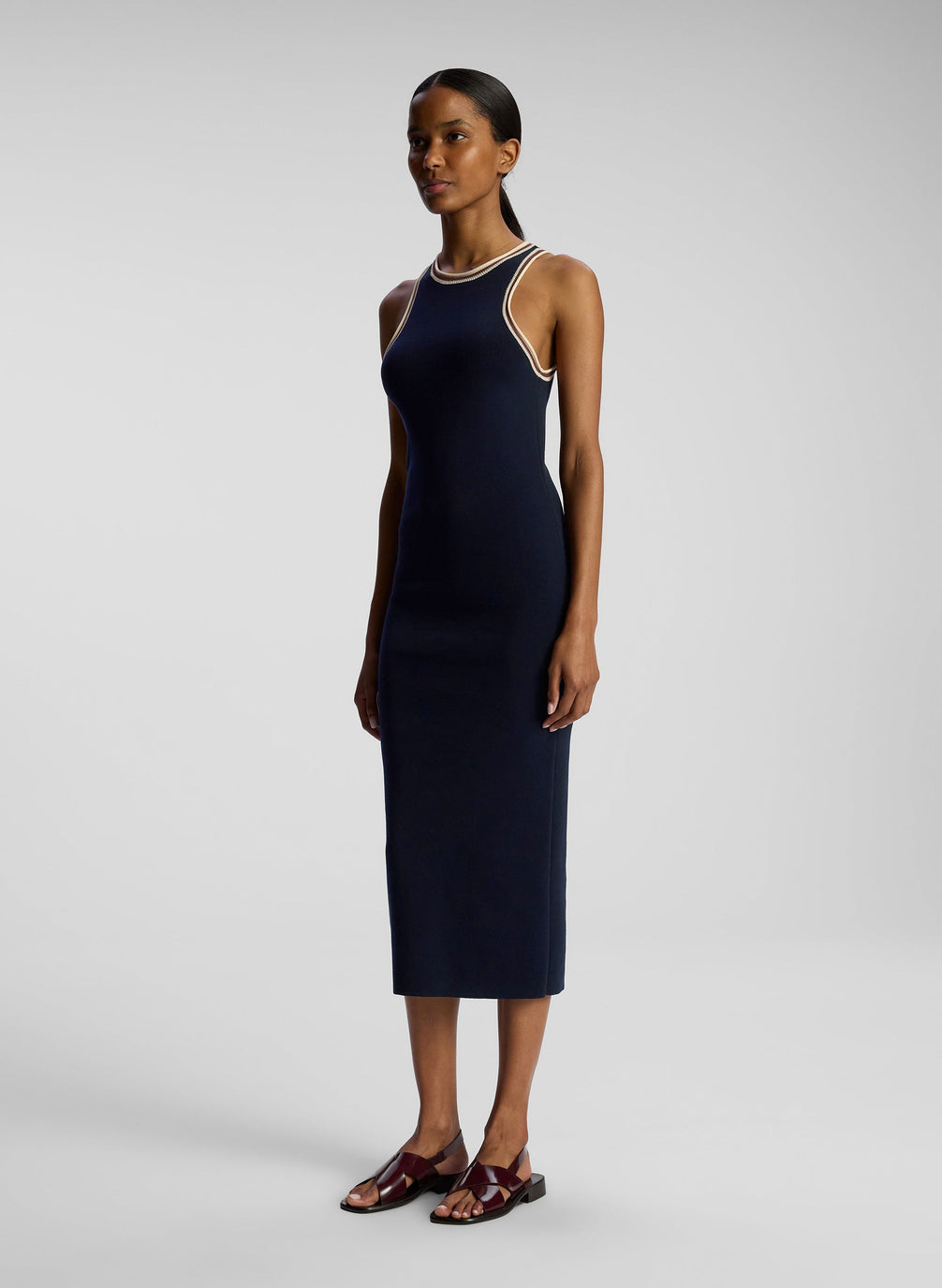 side view of woman wearing navy blue sleeveless knit midi dress