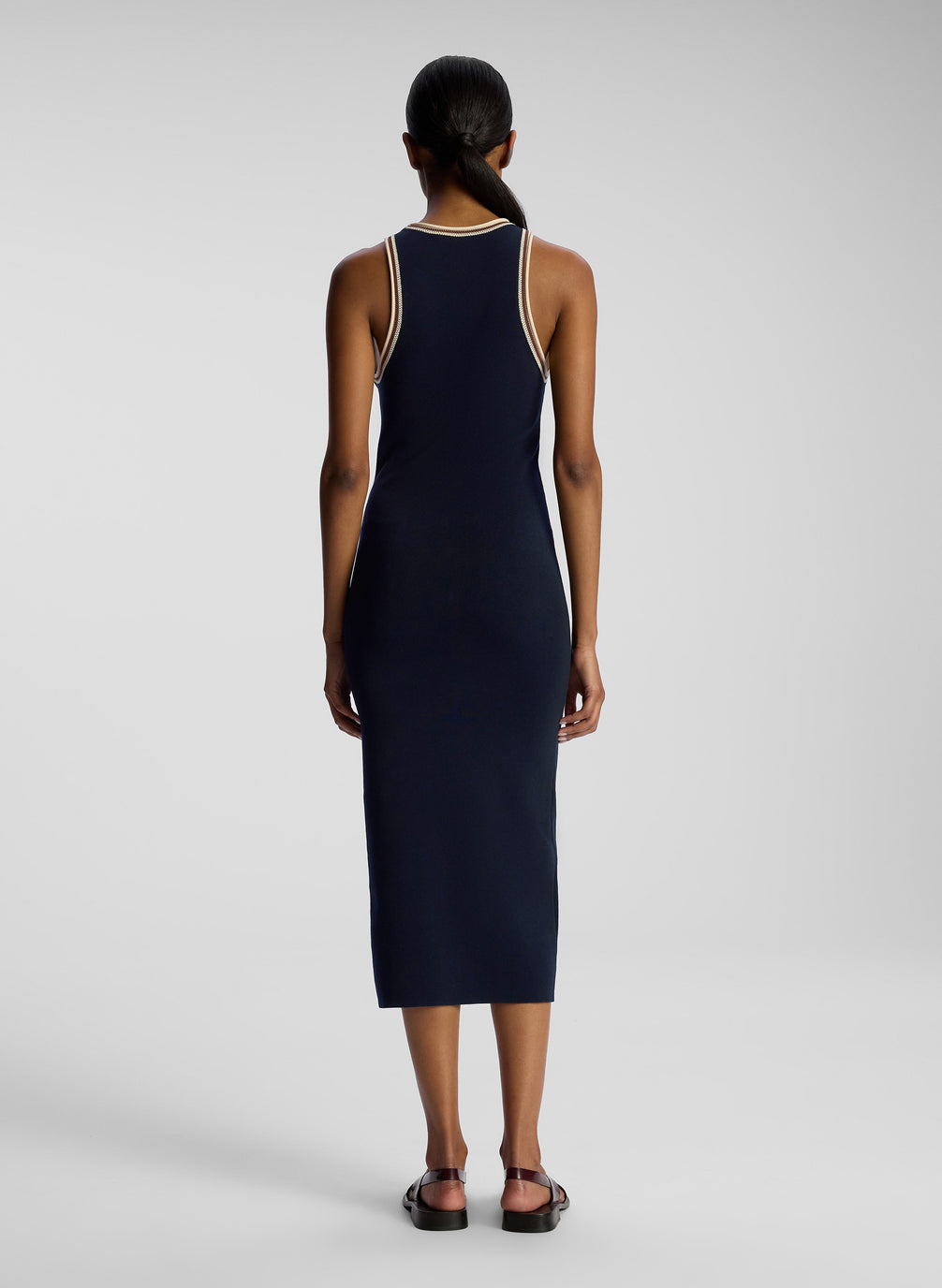 back view of woman wearing navy blue sleeveless knit midi dress