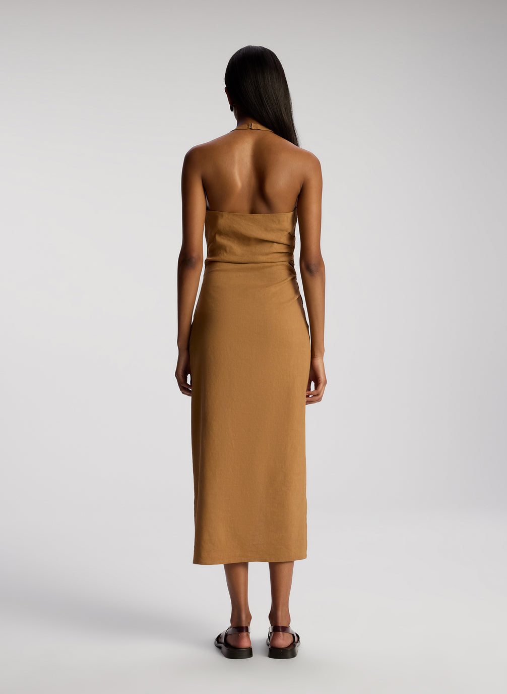 back view of woman wearing brown sleeveless midi dress