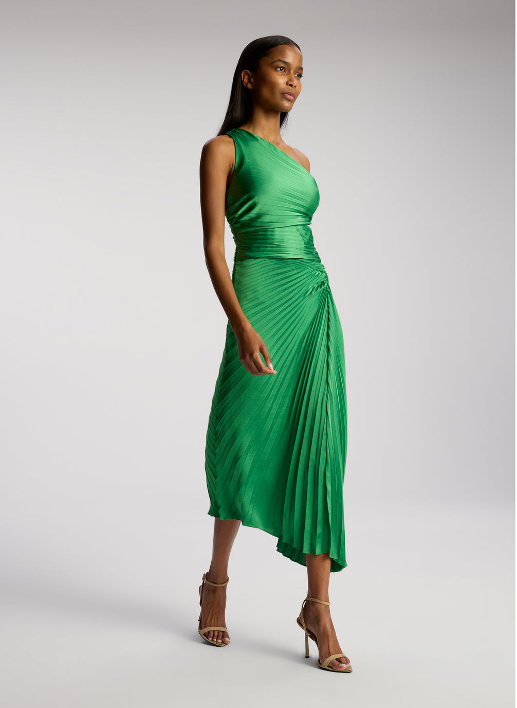 side view of woman wearing green pleated one shoulder dress