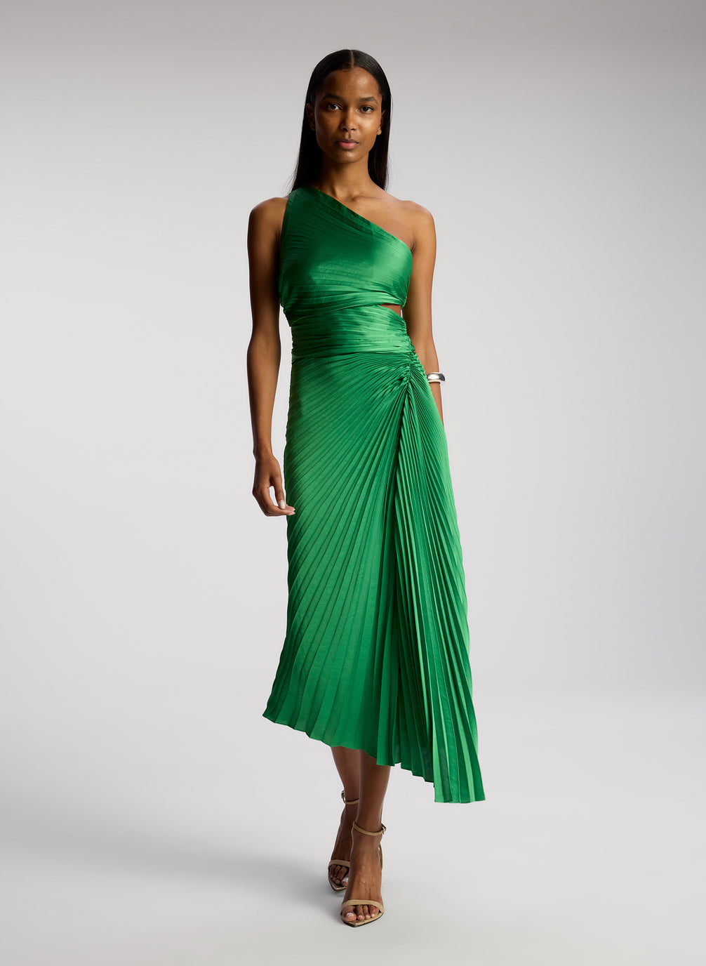 front view of woman wearing green pleated one shoulder dress
