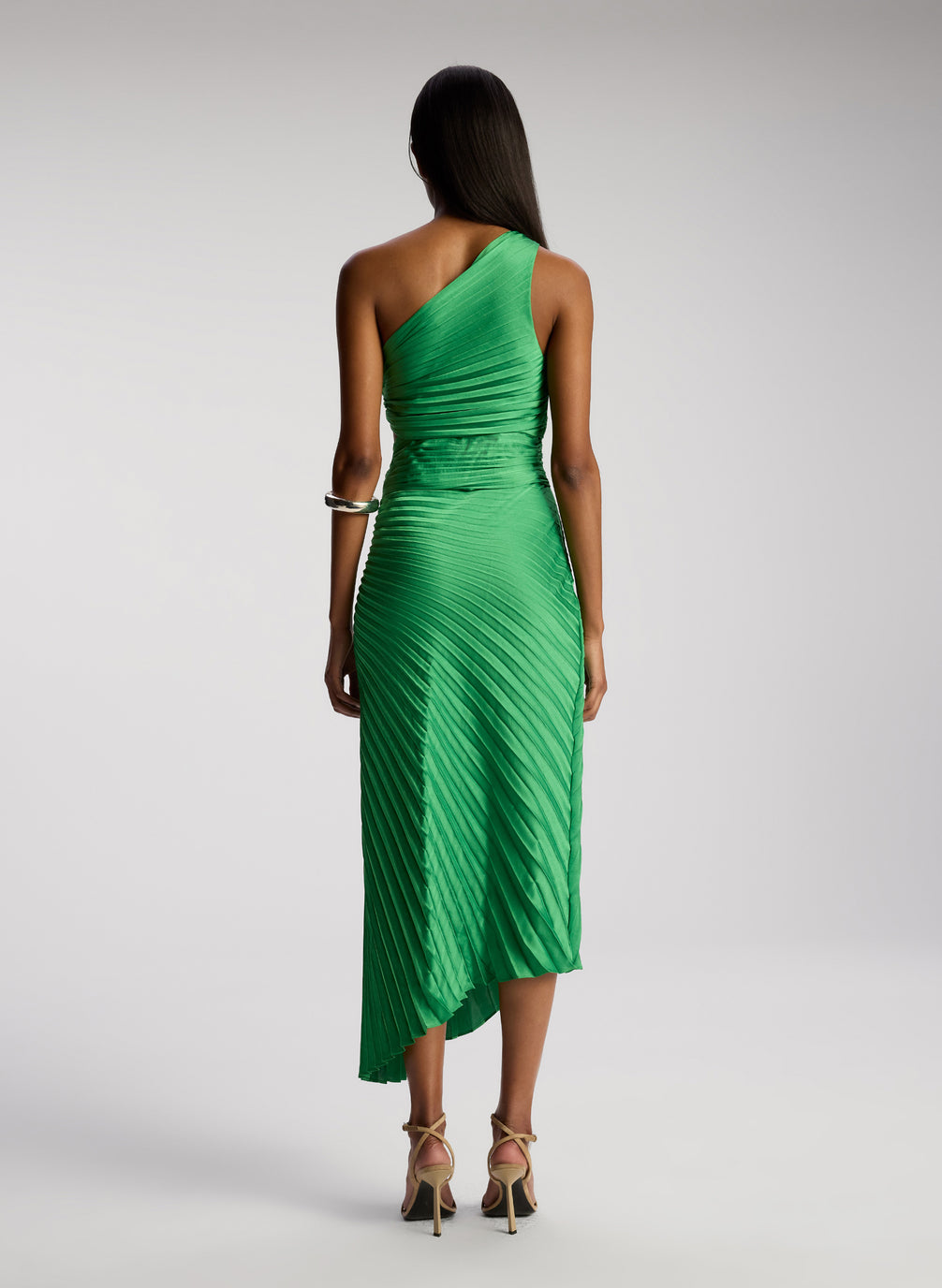 back view of woman wearing green pleated one shoulder dress
