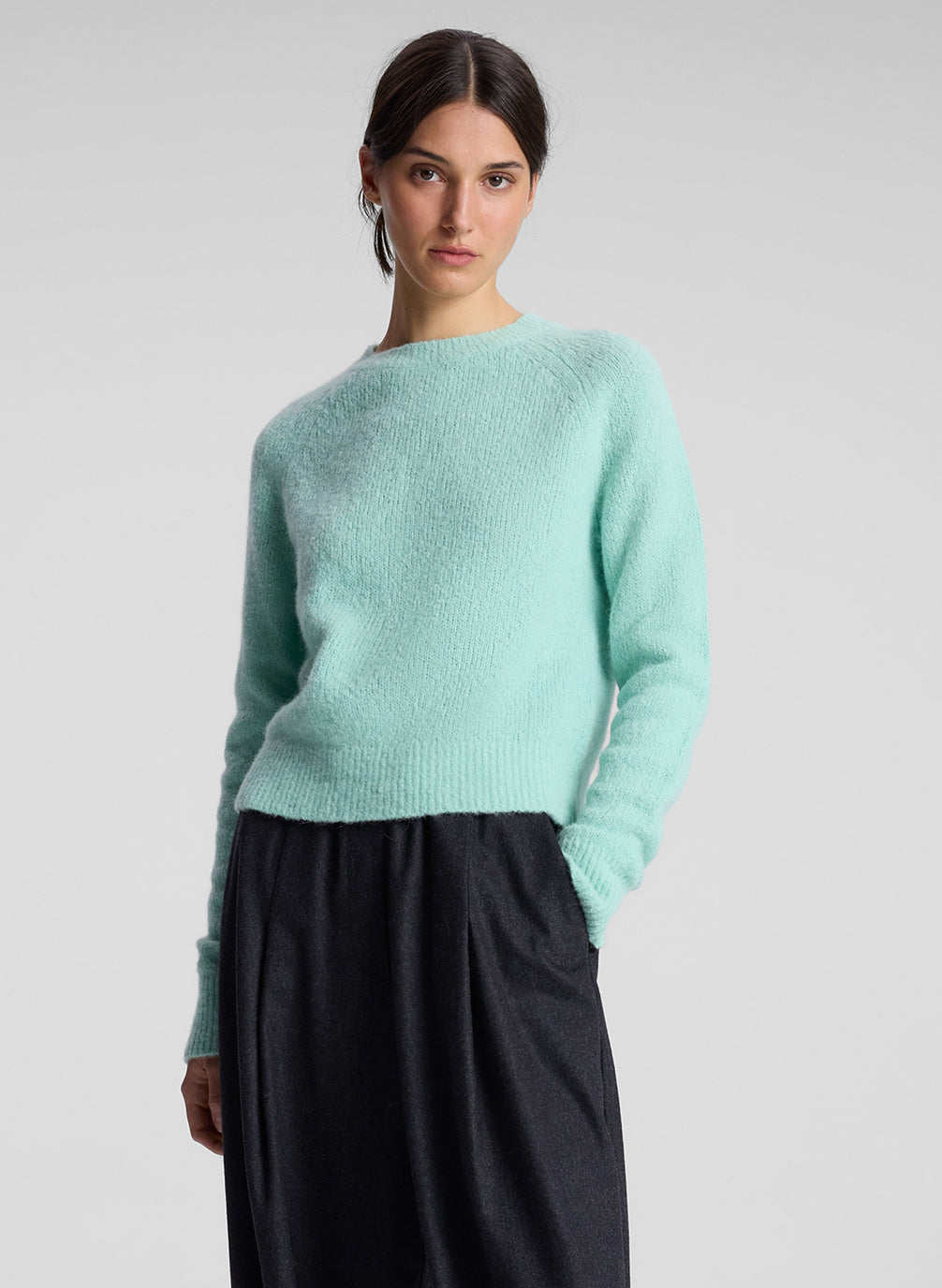 woman wearing aqua sweater and grey pants