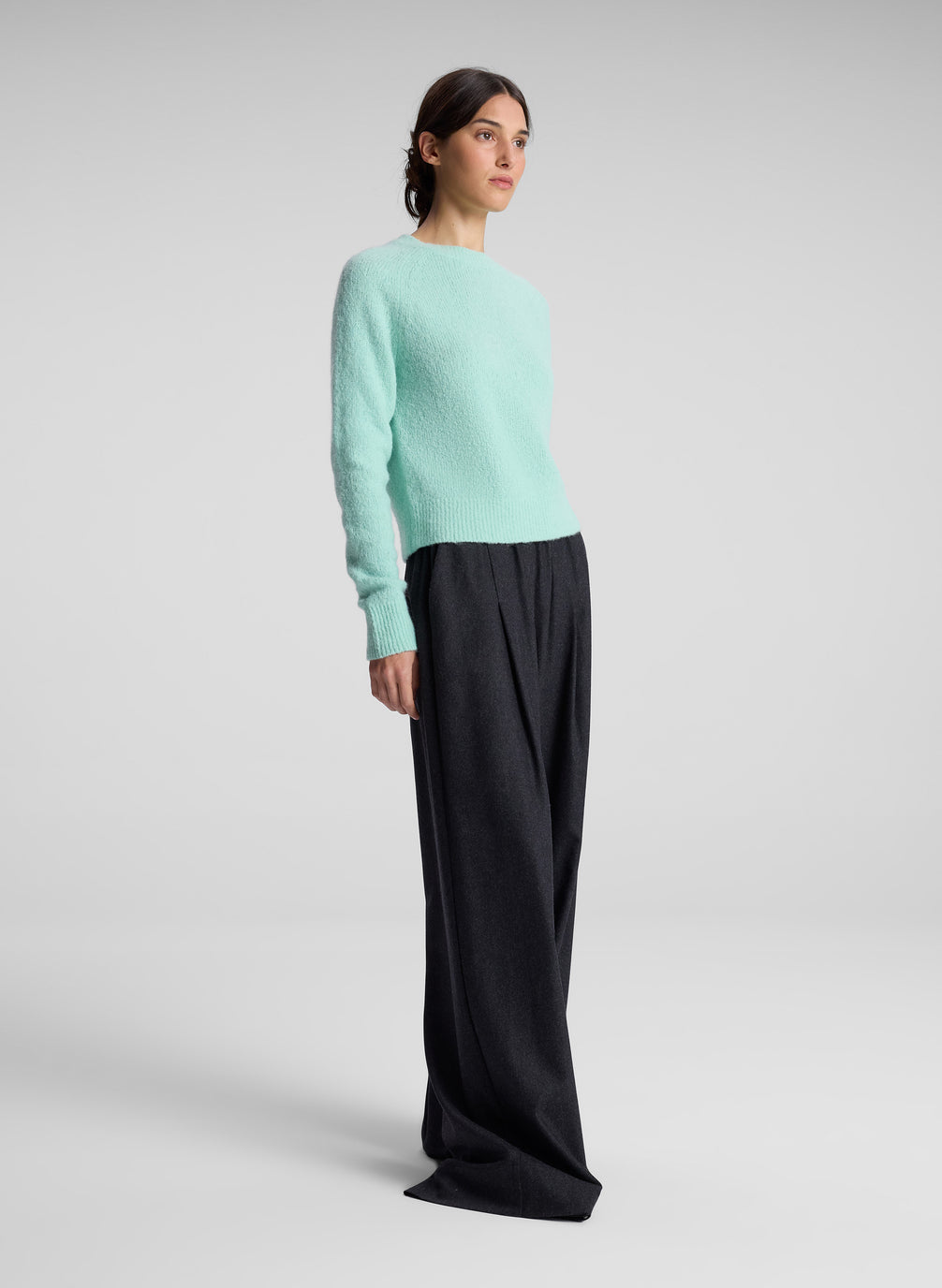 woman wearing aqua sweater and grey pants