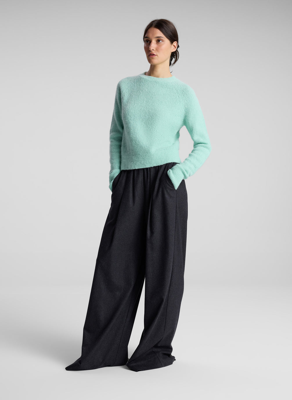 woman wearing aqua sweater and grey pants