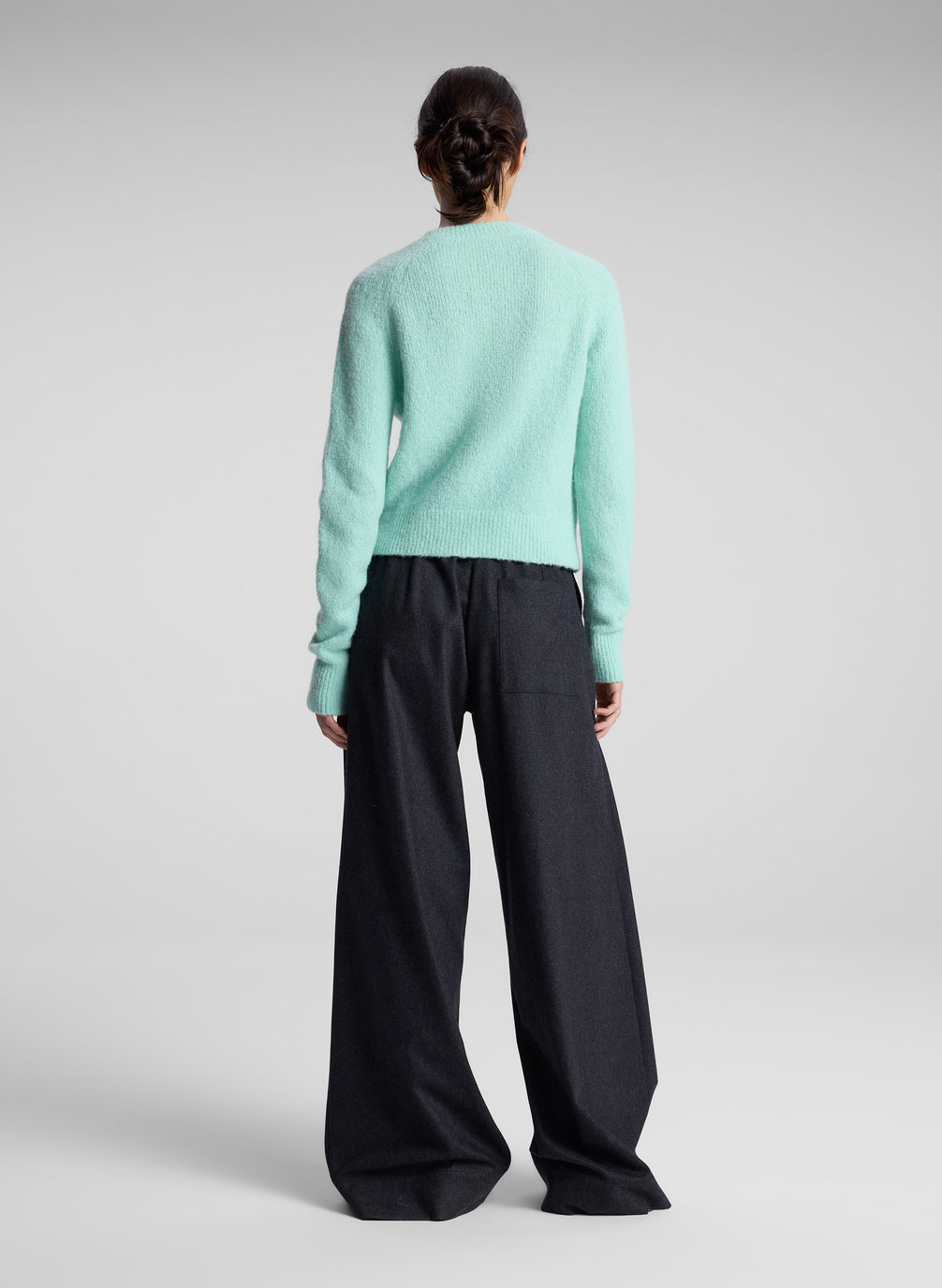 woman wearing aqua sweater and grey pants