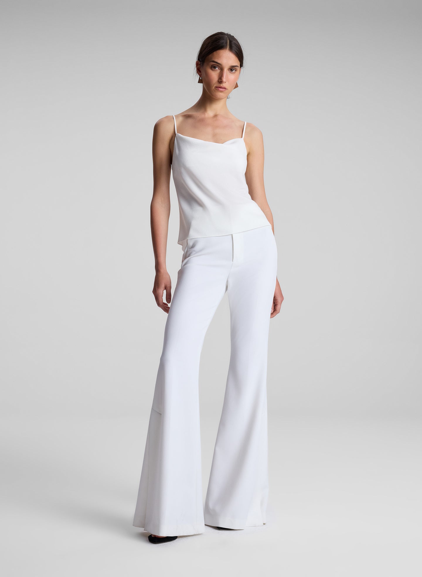 woman wearing white camisole and white flared pants