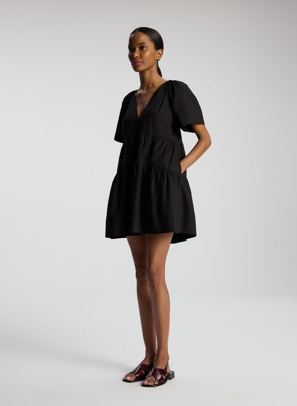 side view of woman wearing black short sleeve mini dress