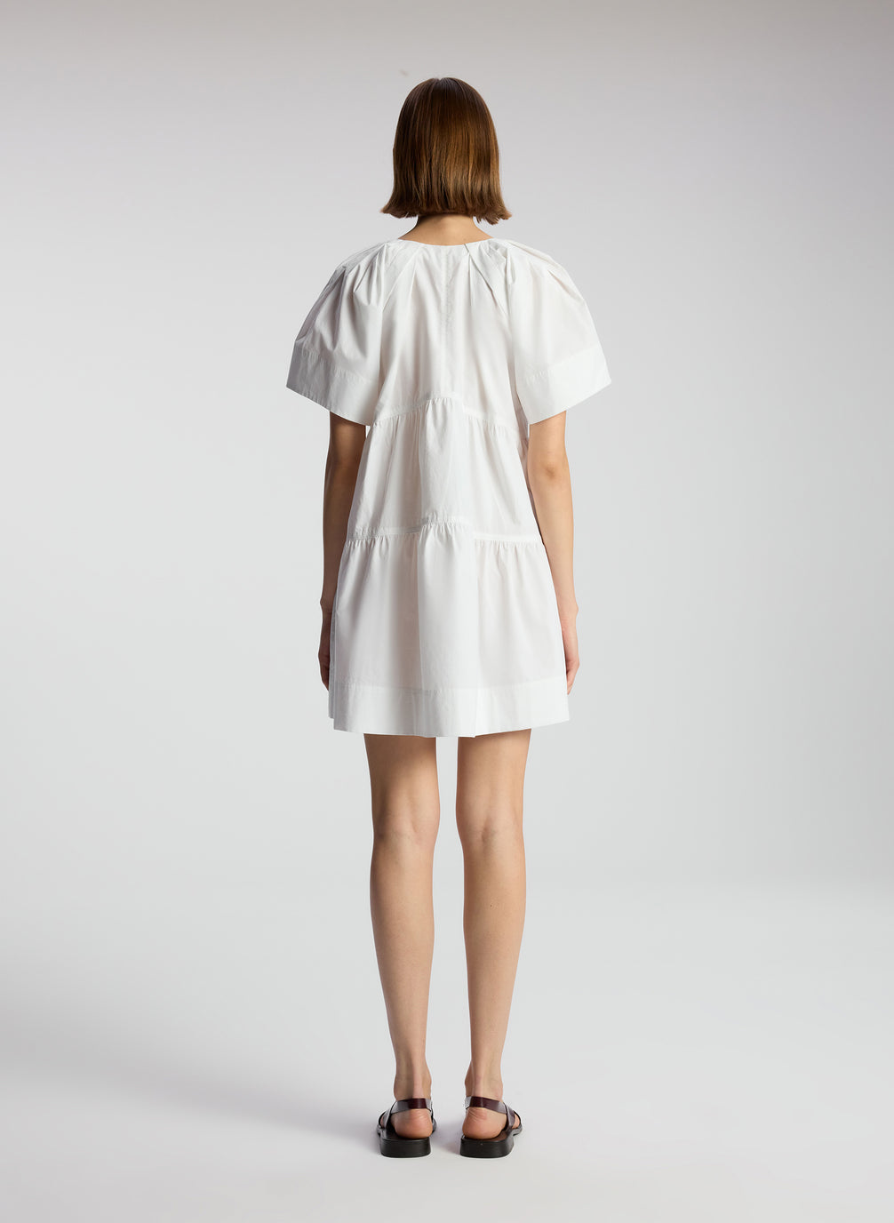back view of woman wearing white short sleeve mini dress
