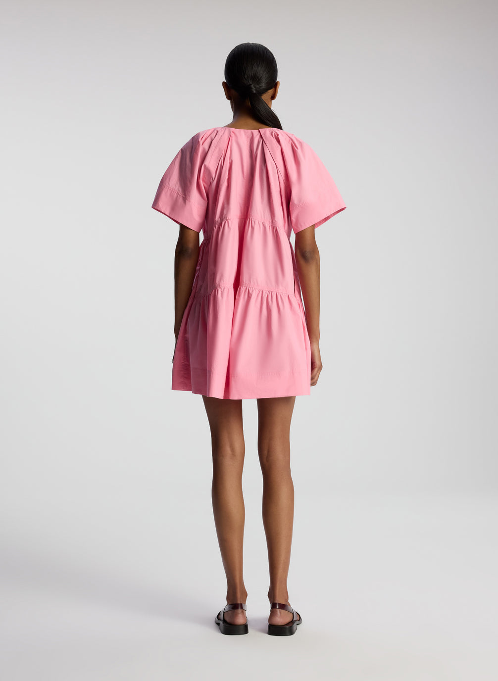 back view of woman wearing pink short sleeve minidress
