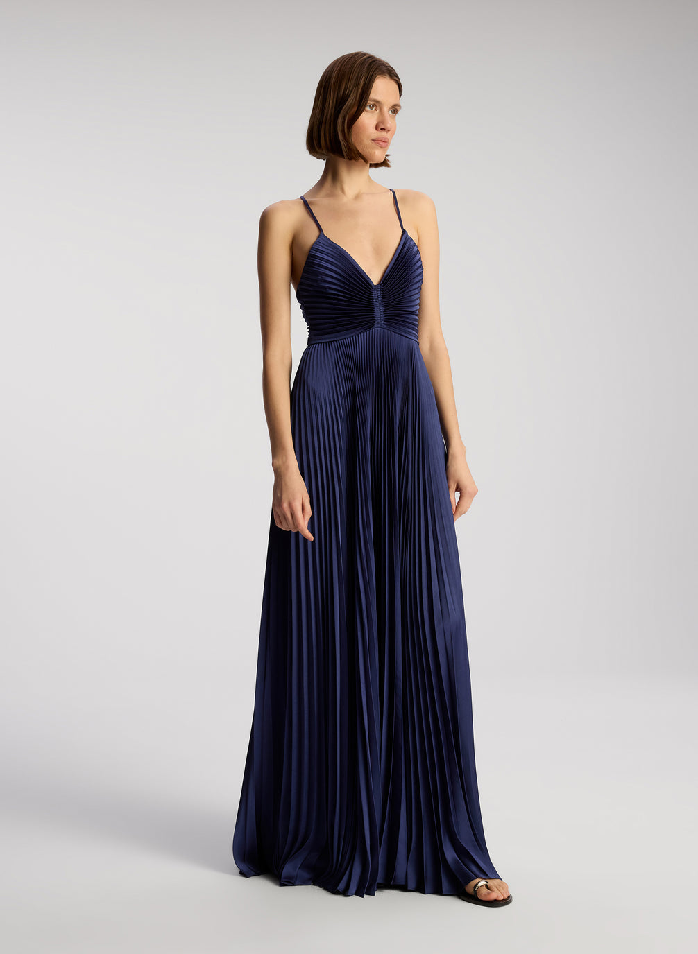 side view of woman wearing navy blue pleated maxi dress
