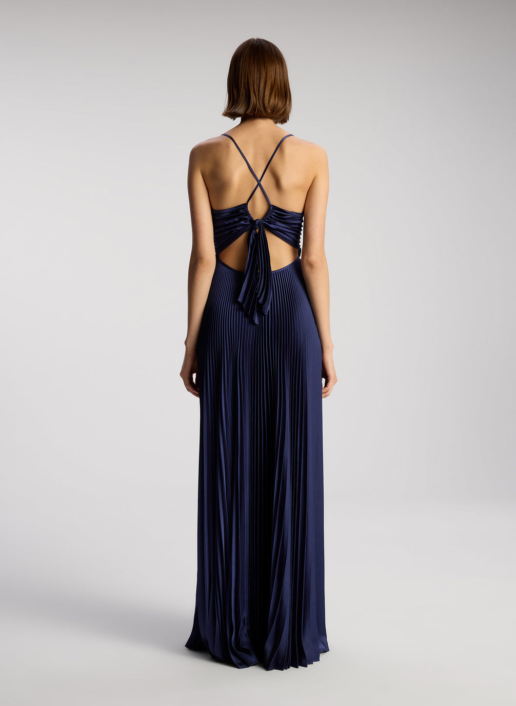 back view of woman wearing navy blue pleated maxi dress